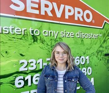 Female employee Katie standing in front of SERVPRO vehicle