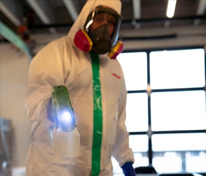 SERVPRO professional fully suited up in PPE spraying ServprOXIDE™