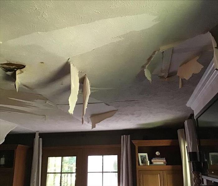 Paint peeling on the ceiling from extensive water damage
